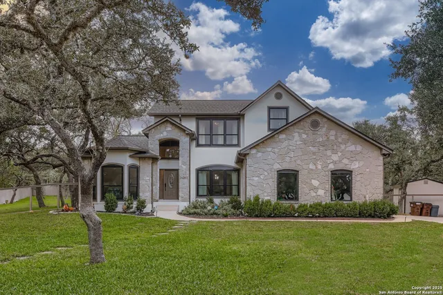a front view of a house with a garden and trees