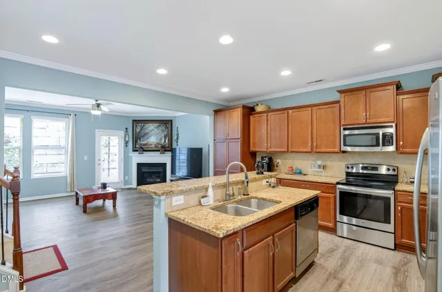 a kitchen with stainless steel appliances granite countertop a sink stove and refrigerator