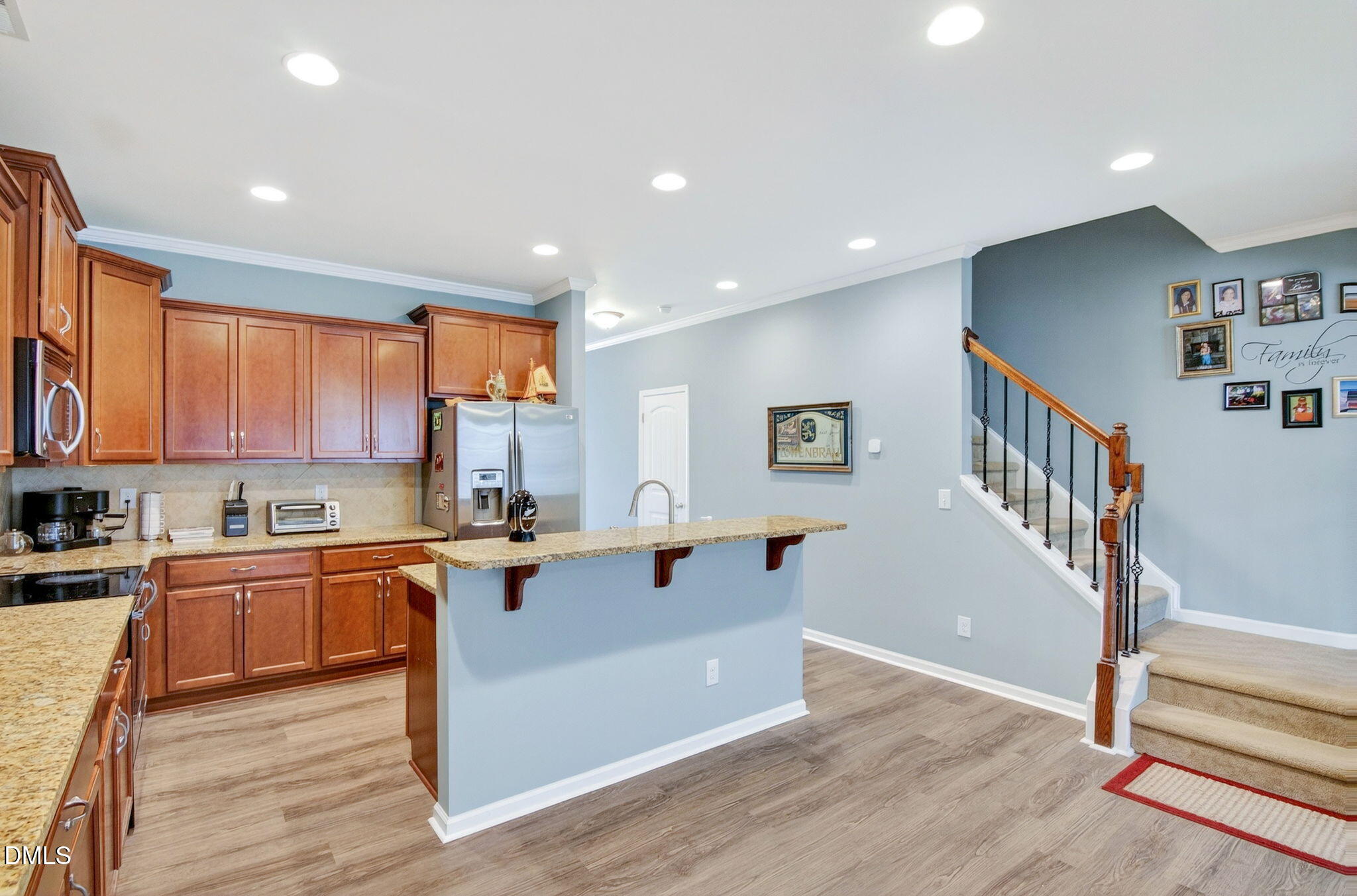 14310 Foxcroft Road Raleigh, NC 27614 - Photo 9 of 32 a kitchen with stainless steel appliances a stove a sink cabinets and a wooden floor