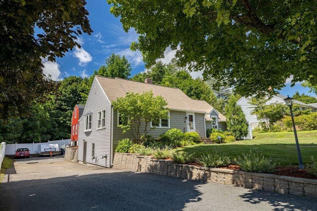 32 Maple Avenue Rutland, MA 01543 - Photo 5 of 42 a front view of a house with a garden and plants