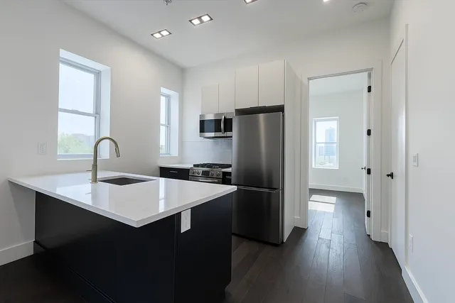 a kitchen with stainless steel appliances a refrigerator and a sink
