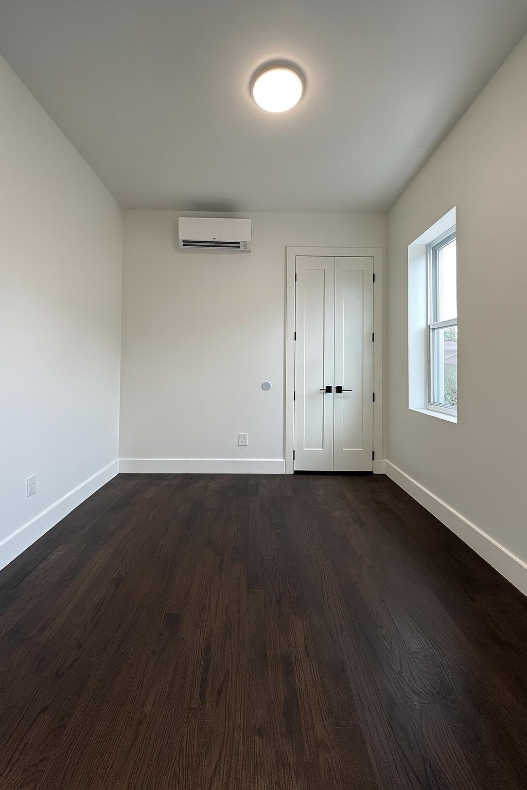272 Hoboken Avenue, Unit 5 Jersey City, NJ 07306 - Photo 12 of 16 an empty room with wooden floor and windows