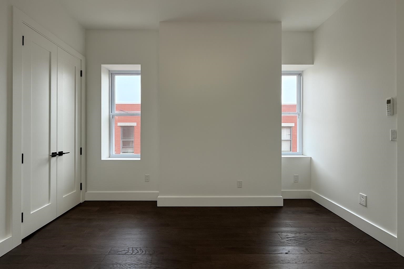272 Hoboken Avenue, Unit 5 Jersey City, NJ 07306 - Photo 13 of 16 an empty room with wooden floor and windows