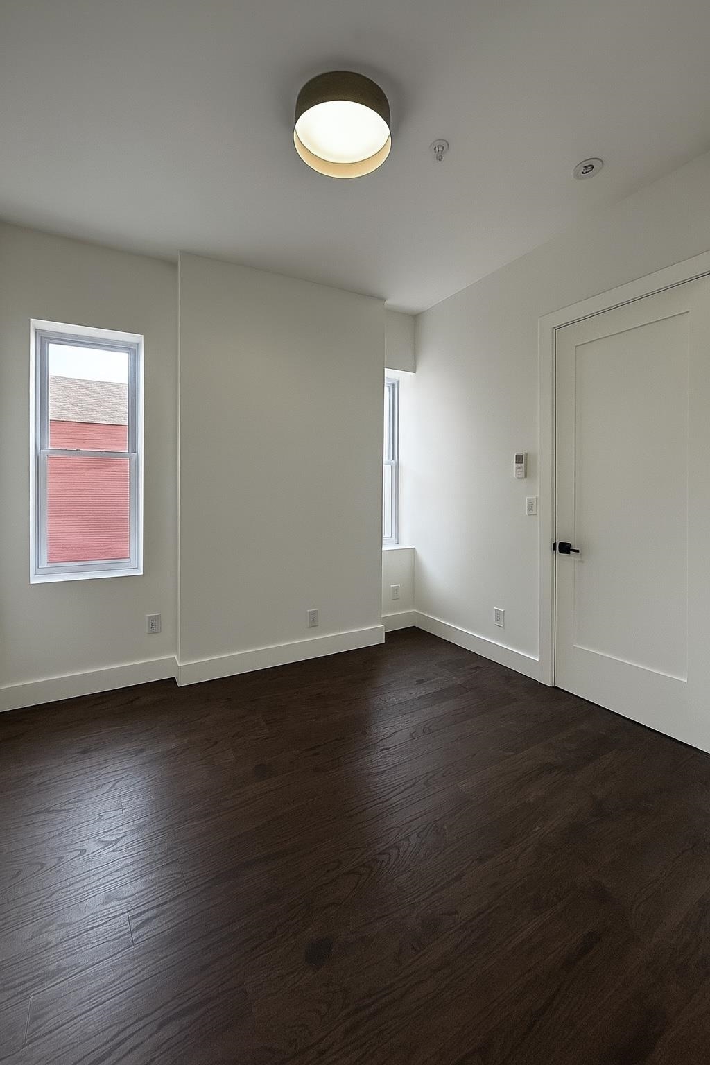 272 Hoboken Avenue, Unit 5 Jersey City, NJ 07306 - Photo 14 of 16 an empty room with wooden floor and windows