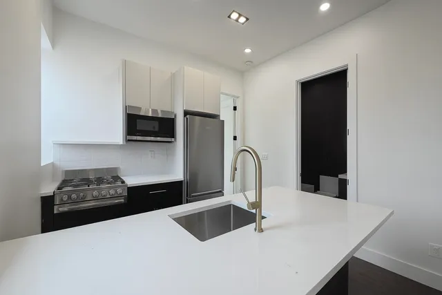 a kitchen with stainless steel appliances a sink and cabinets