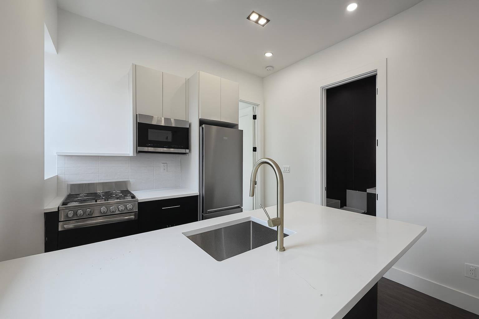 272 Hoboken Avenue, Unit 5 Jersey City, NJ 07306 - Photo 3 of 16 a kitchen with stainless steel appliances a sink and cabinets
