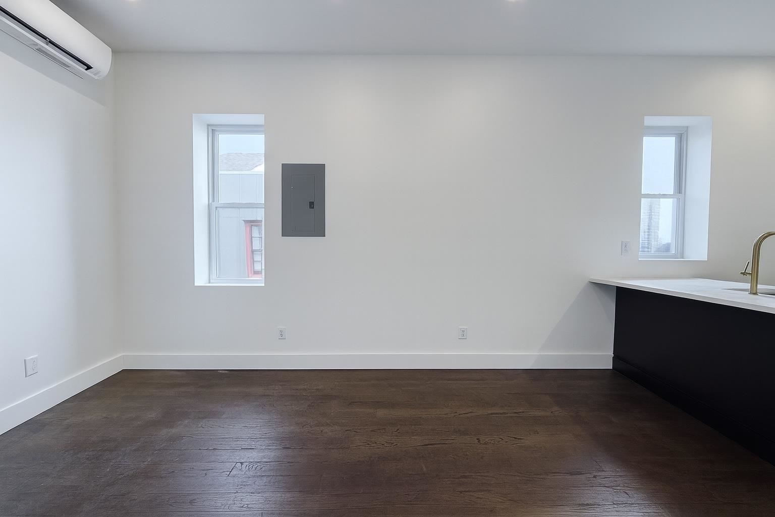 272 Hoboken Avenue, Unit 5 Jersey City, NJ 07306 - Photo 4 of 16 an empty room with wooden floor and windows