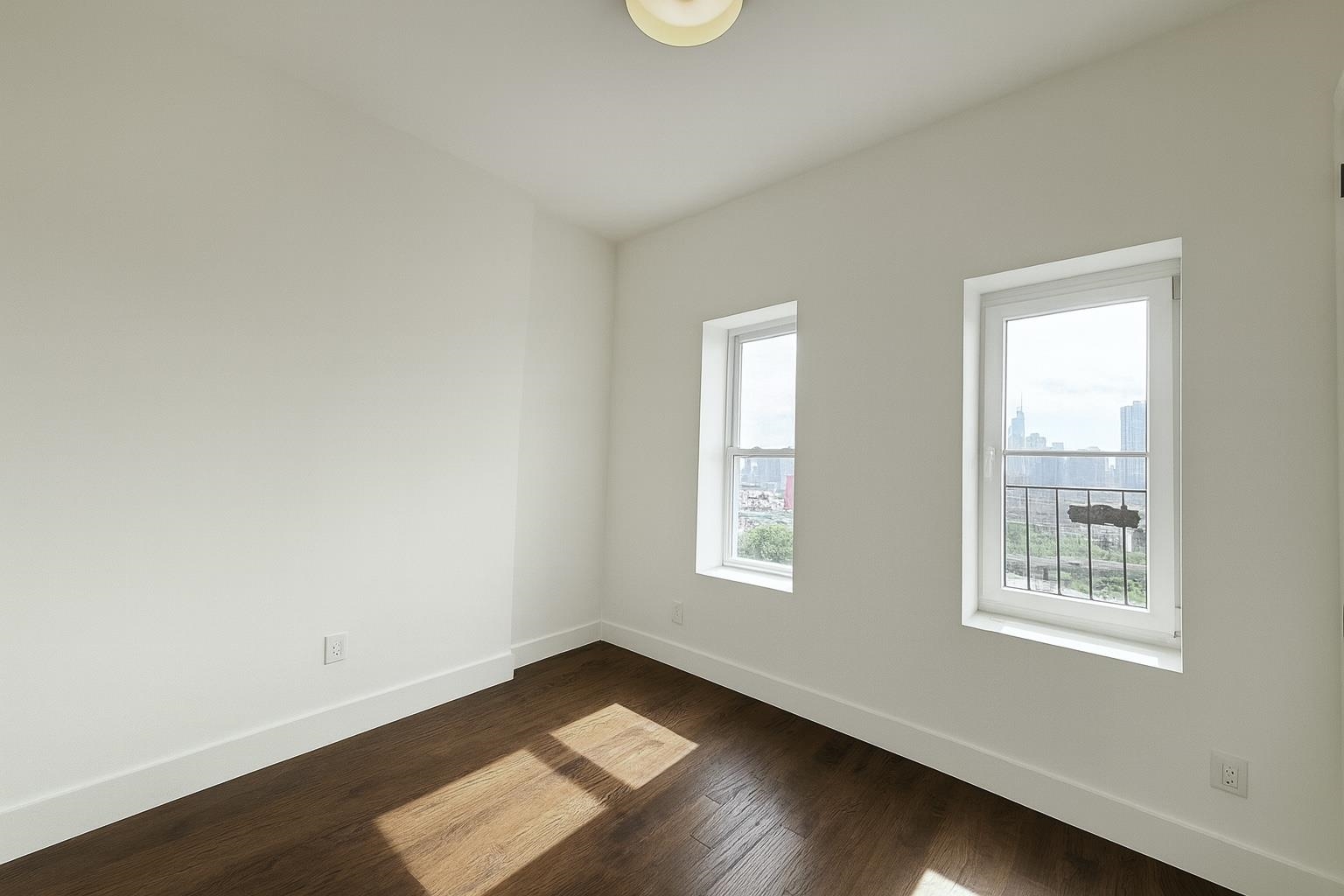 272 Hoboken Avenue, Unit 5 Jersey City, NJ 07306 - Photo 9 of 16 a view of an empty room with wooden floor and a window