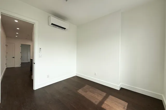 an empty room with wooden floor and a window