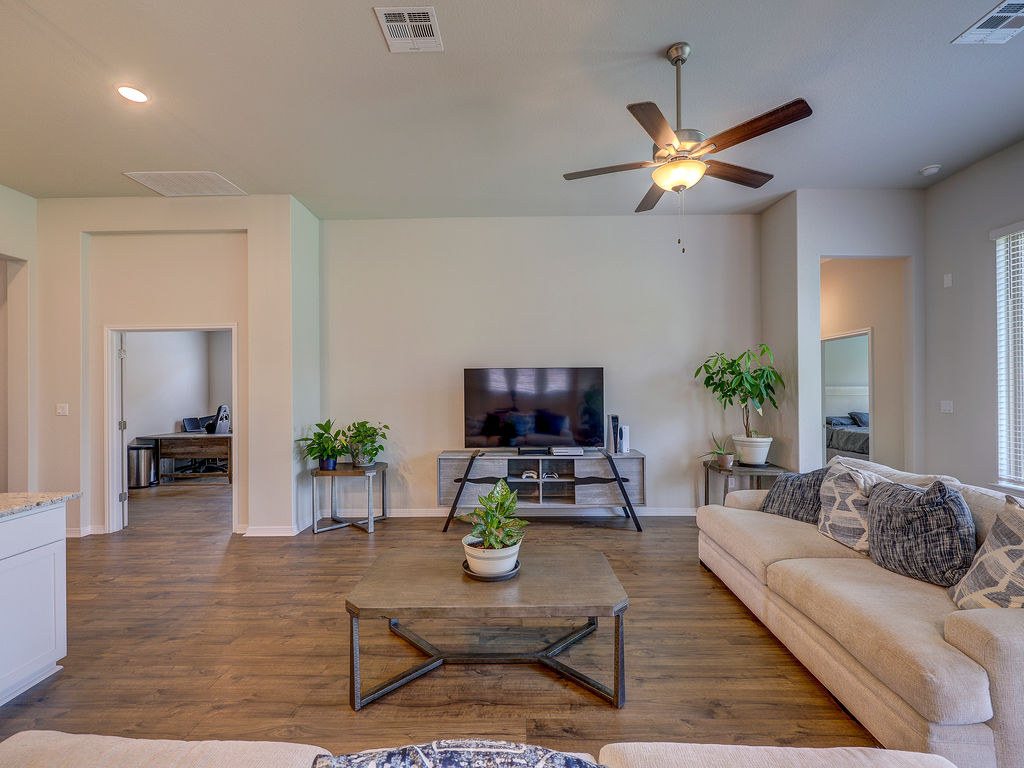 229 Heartleaf Road San Marcos, TX 78666 - Photo 20 of 40 Relax in a generously proportioned living area featuring rich wood-look flooring and a modern ceiling fan.