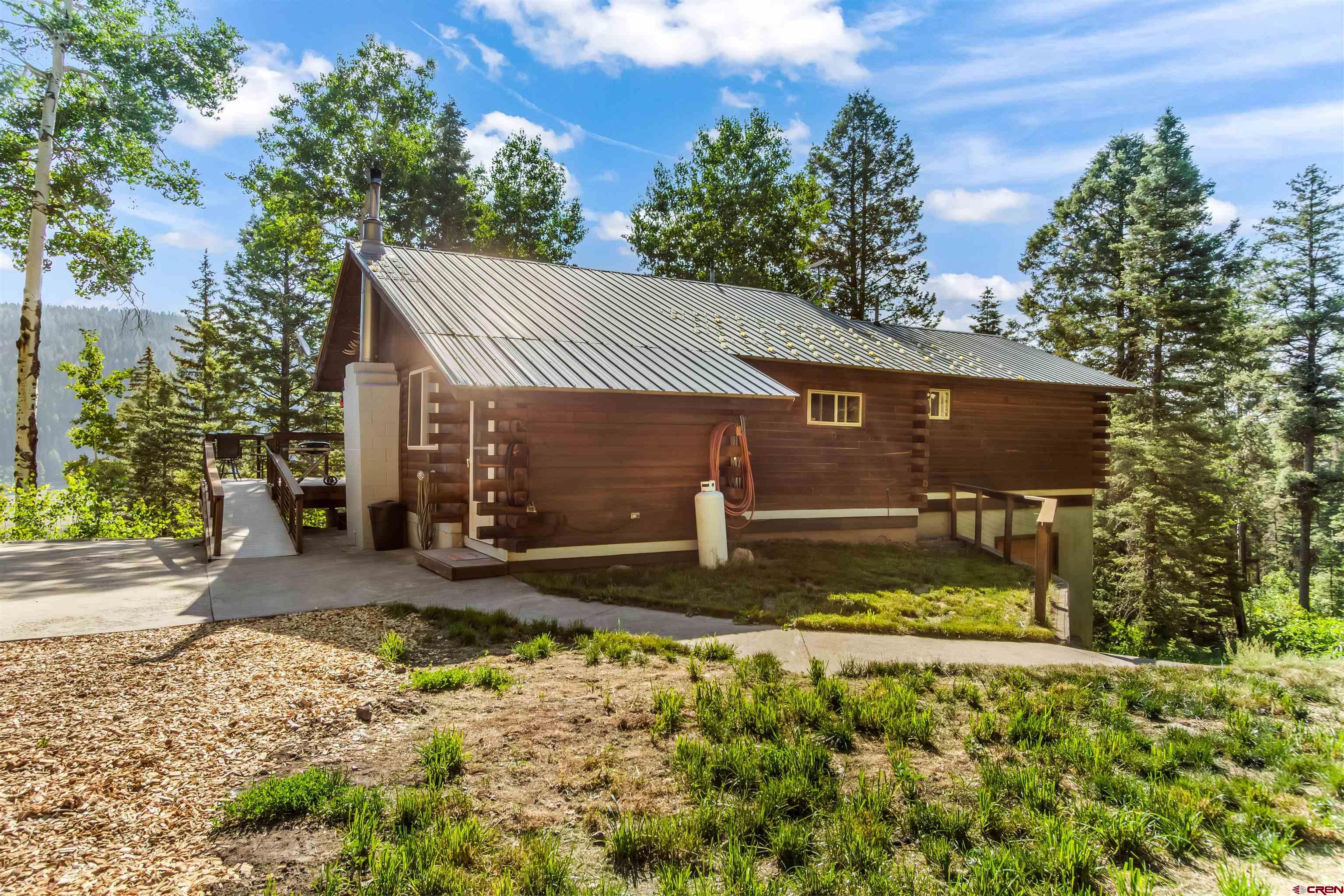 504 Weminuche Road Pagosa Springs, CO 81147 - Photo 5 of 44 a view of a house with large tree and wooden fence