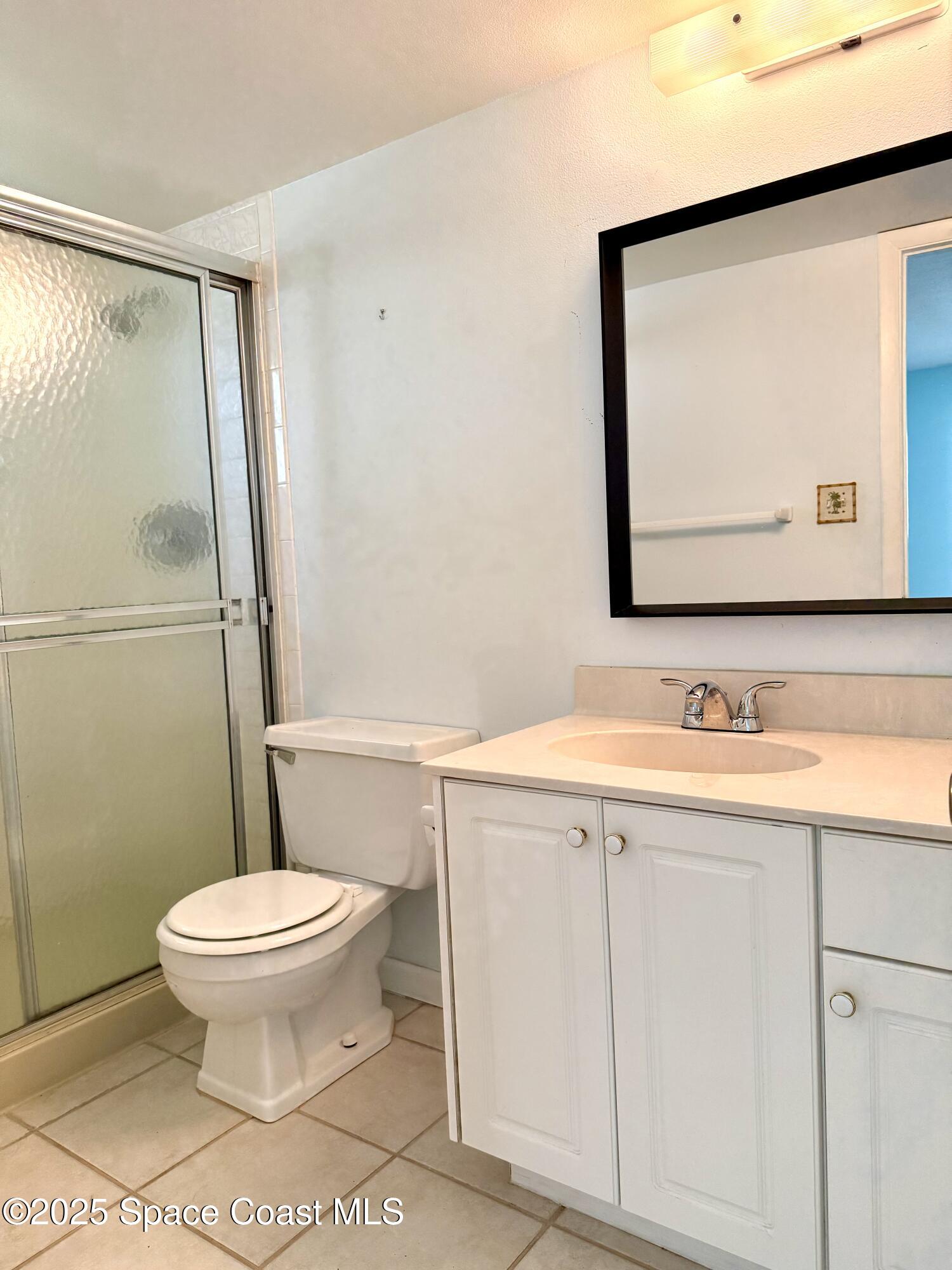 417 Ibis Lane, Unit 96 Satellite Beach, FL 32937 - Photo 18 of 29 a bathroom with a sink a toilet and mirror