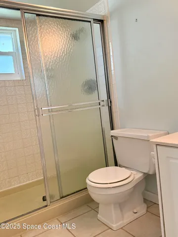 a white toilet sitting next to a shower