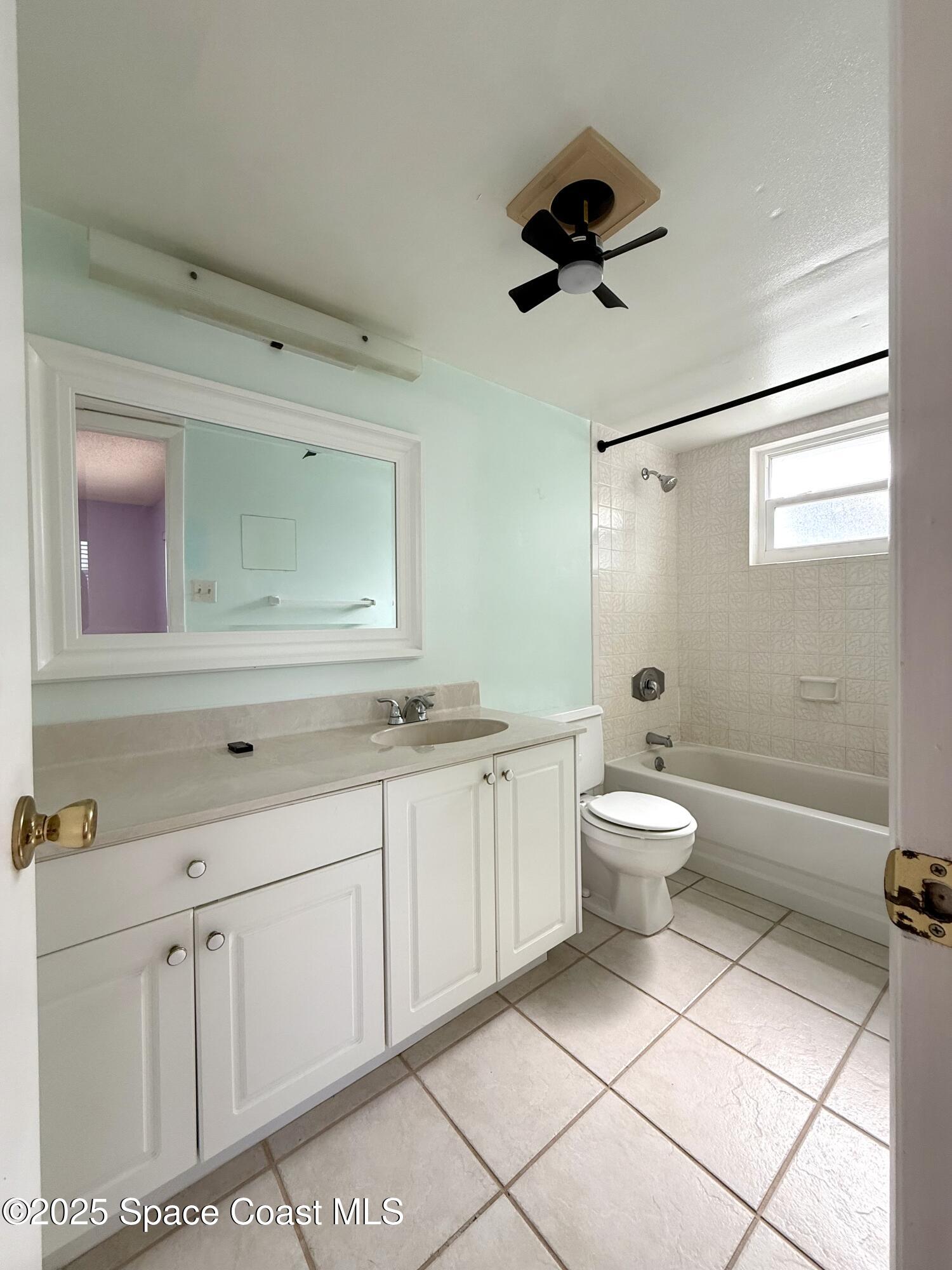 417 Ibis Lane, Unit 96 Satellite Beach, FL 32937 - Photo 21 of 29 a bathroom with a toilet sink double vanity and mirror