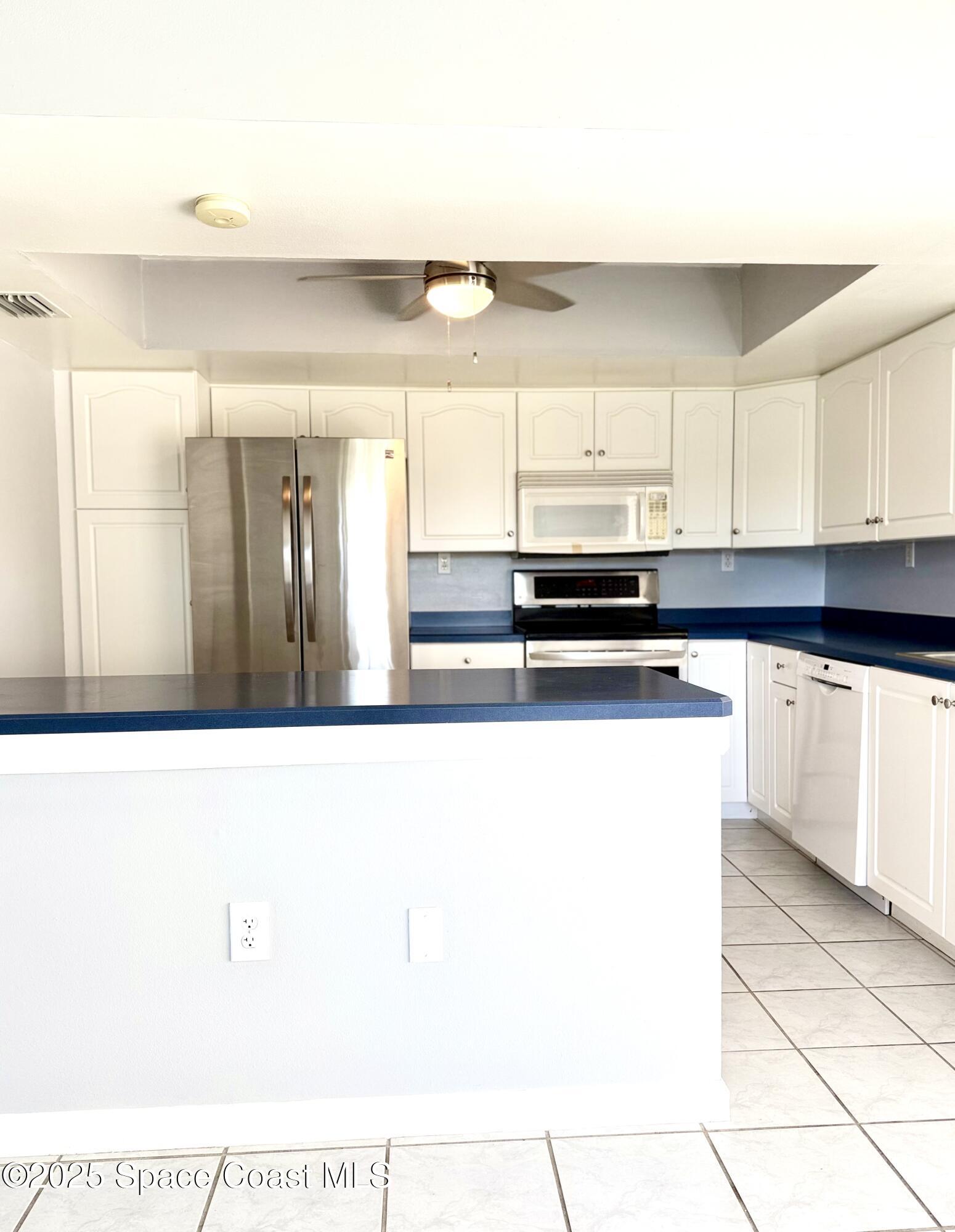417 Ibis Lane, Unit 96 Satellite Beach, FL 32937 - Photo 9 of 29 a kitchen with stainless steel appliances a sink and a refrigerator