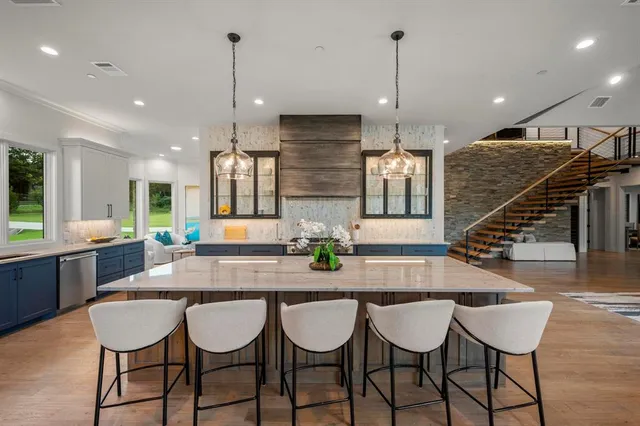 a kitchen with stainless steel appliances granite countertop a kitchen island a table and chairs