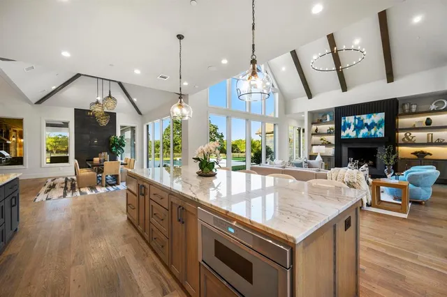 a kitchen with stainless steel appliances granite countertop a stove and a wooden floors
