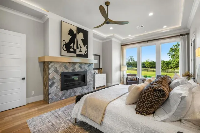 a bedroom with a bed a fireplace and a large window