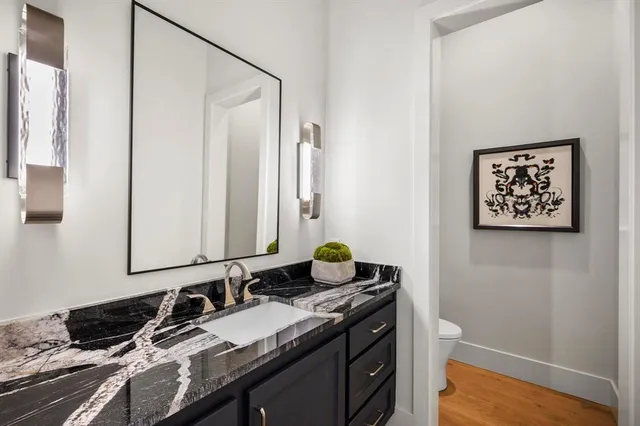 a bathroom with a granite countertop sink a mirror and a shower