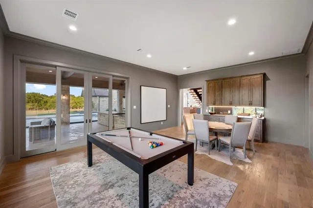 a living room with game table and a wooden floor
