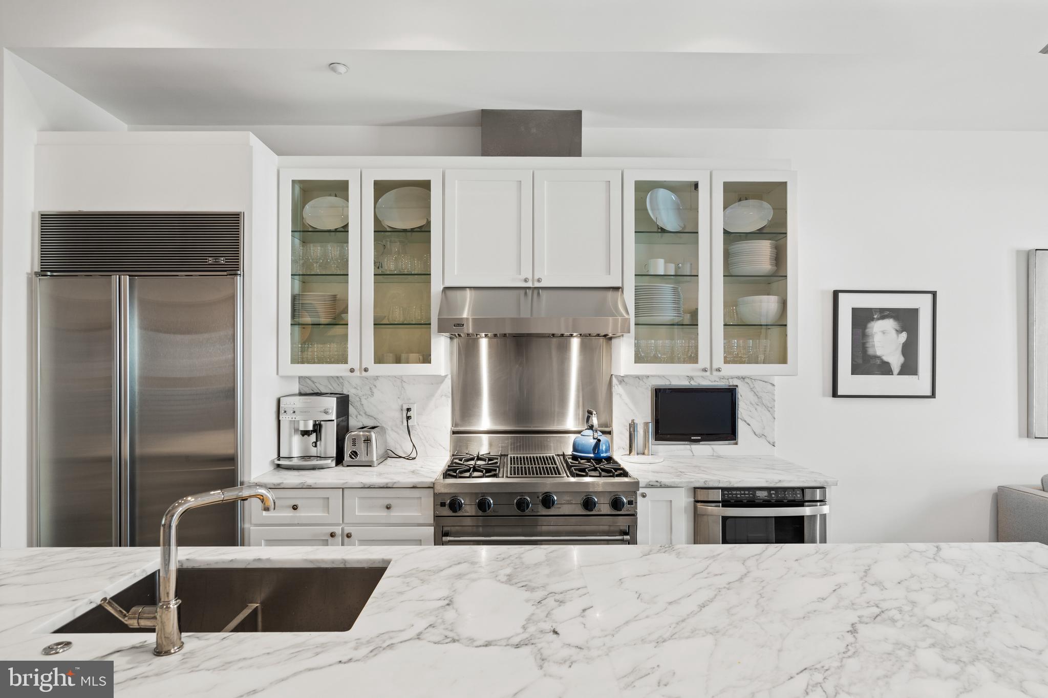 1341 Q Street Northwest, Unit B Washington, DC 20009 - Photo 8 of 31 a kitchen with stainless steel appliances kitchen island a stove a sink and a microwave