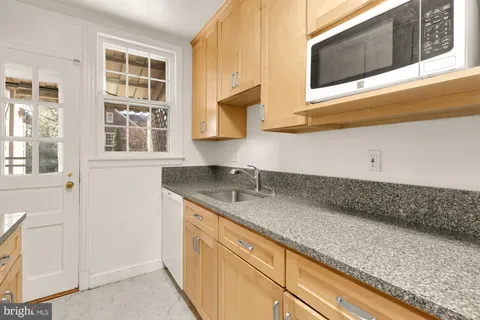a kitchen with stainless steel appliances granite countertop a sink and a microwave