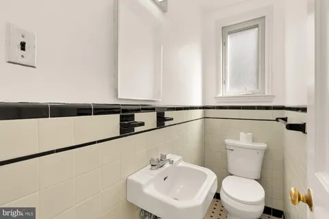 a bathroom with a sink a toilet and mirror
