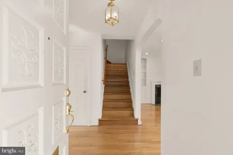 a view of a hallway with wooden floor and staircase