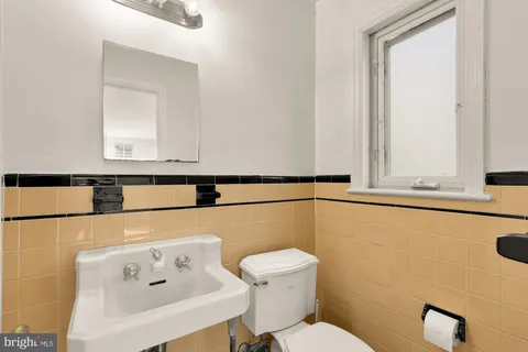 a bathroom with a toilet sink and mirror