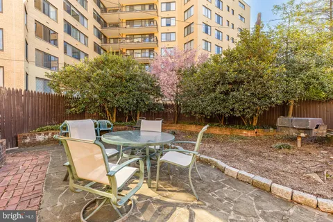 a view of a patio with a table and chairs next to a yard
