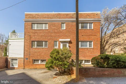 a picture of a bench in front of a white house