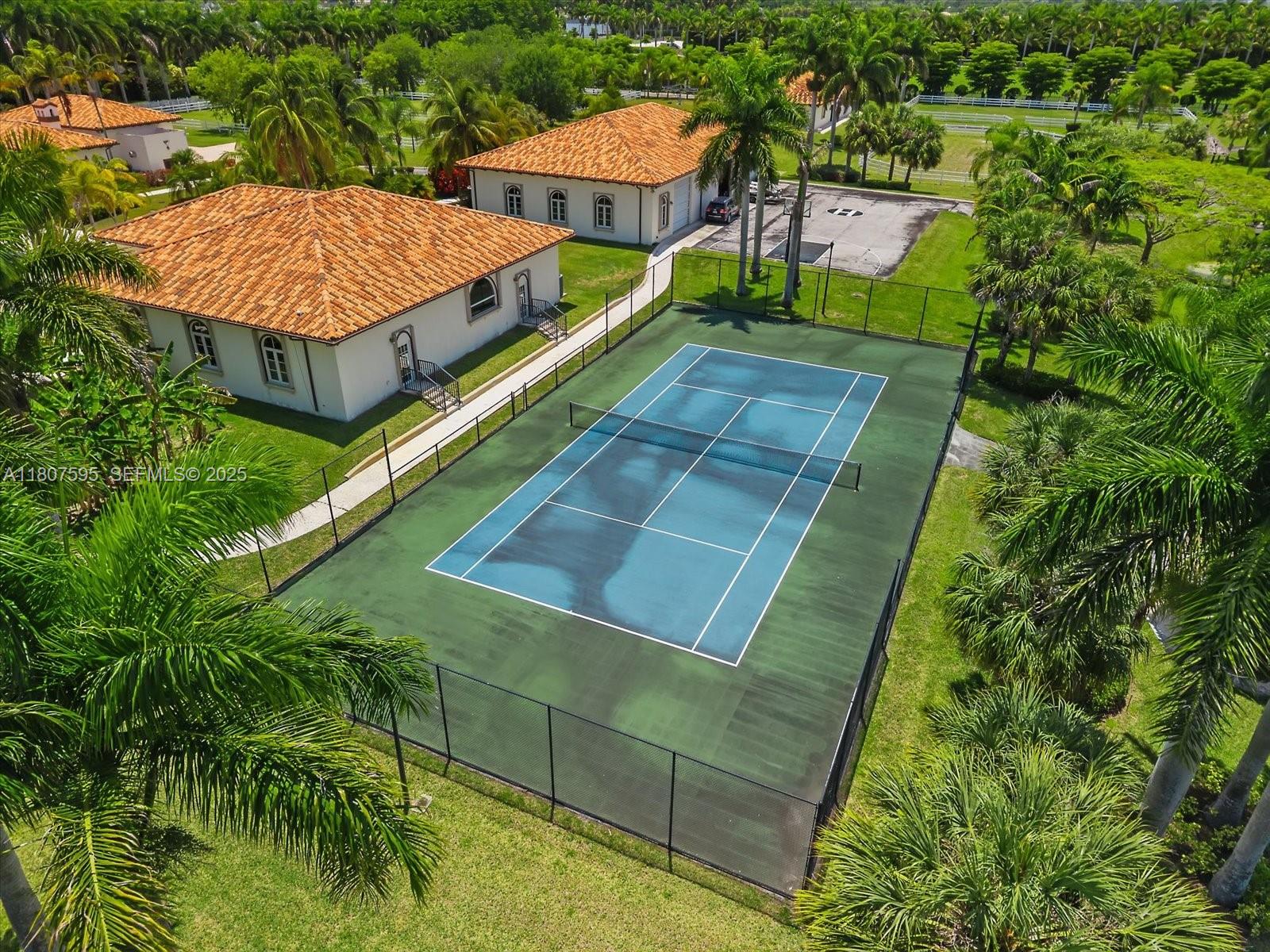 18451 Southwest 158th Street Miami, FL 33187 - Photo 44 of 45 a view of a house with pool and a lawn chairs under an umbrella