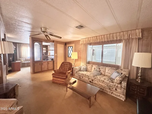 a living room with furniture a flat screen tv and large windows