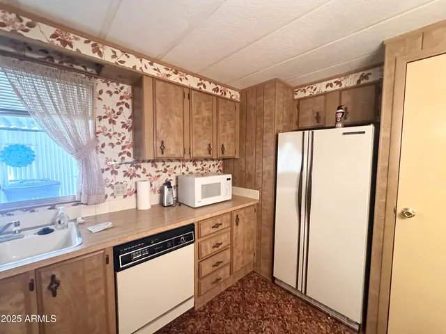 a bed sitting in a spacious bedroom next to a window and a bathroom