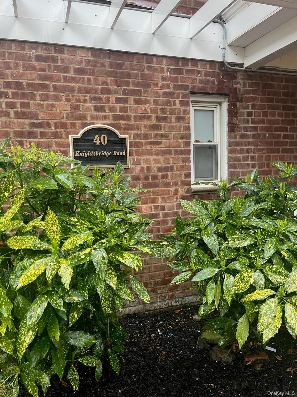 40 Knightsbridge Road, Unit 2C Great Neck, NY 11021 - Photo 1 of 1 a brick building with a garden