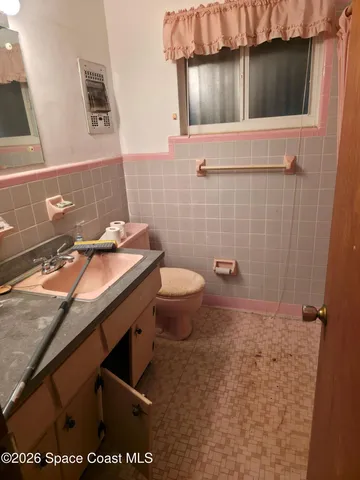 a bathroom with a granite countertop sink a toilet and a mirror