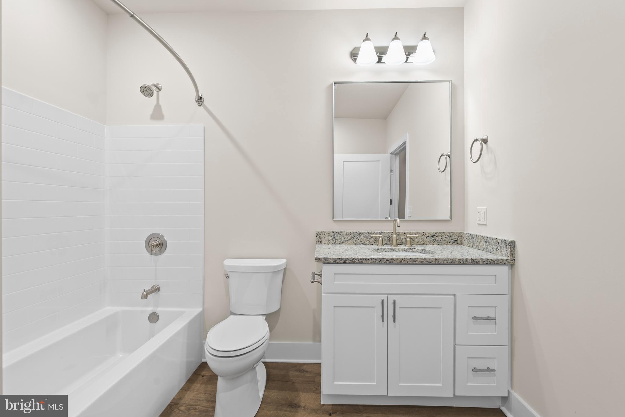30 West Broad Street Souderton, PA 18964 - Photo 14 of 40 a bathroom with a granite countertop sink a toilet mirror and bathtub