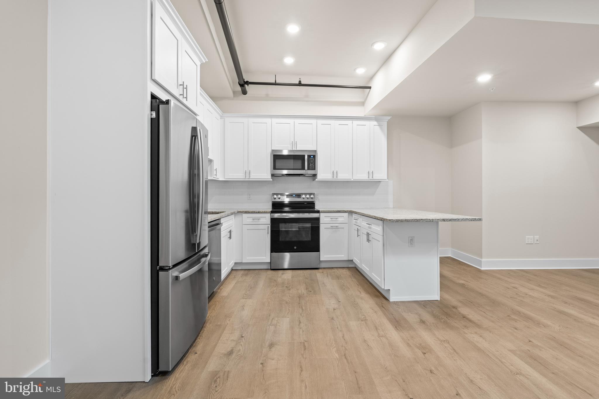 30 West Broad Street Souderton, PA 18964 - Photo 19 of 40 a kitchen with granite countertop a refrigerator and a stove top oven