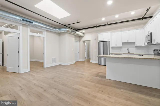 a kitchen with a refrigerator cabinets stainless steel appliances and a window