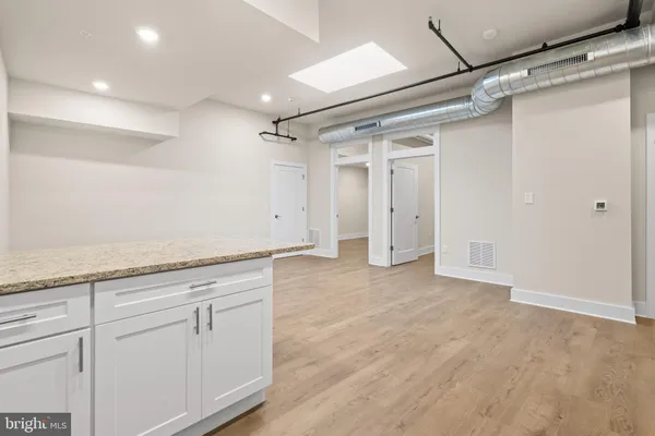 a kitchen with granite countertop a refrigerator and a stove top oven