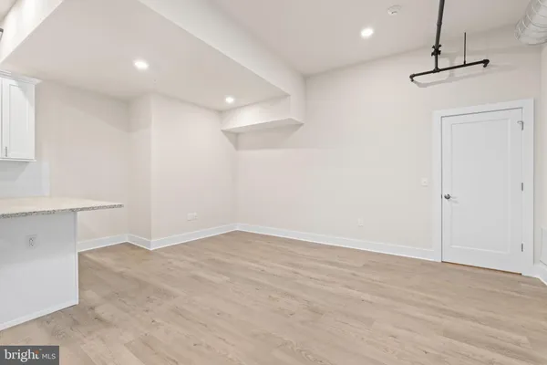 a view of large kitchen with granite countertop cabinets and refrigerator