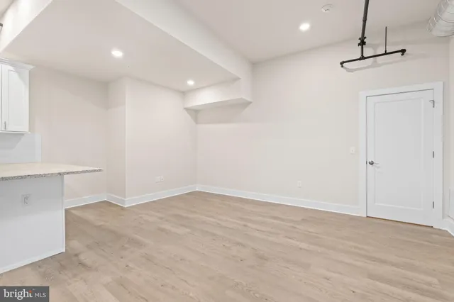 a view of large kitchen with granite countertop cabinets and refrigerator