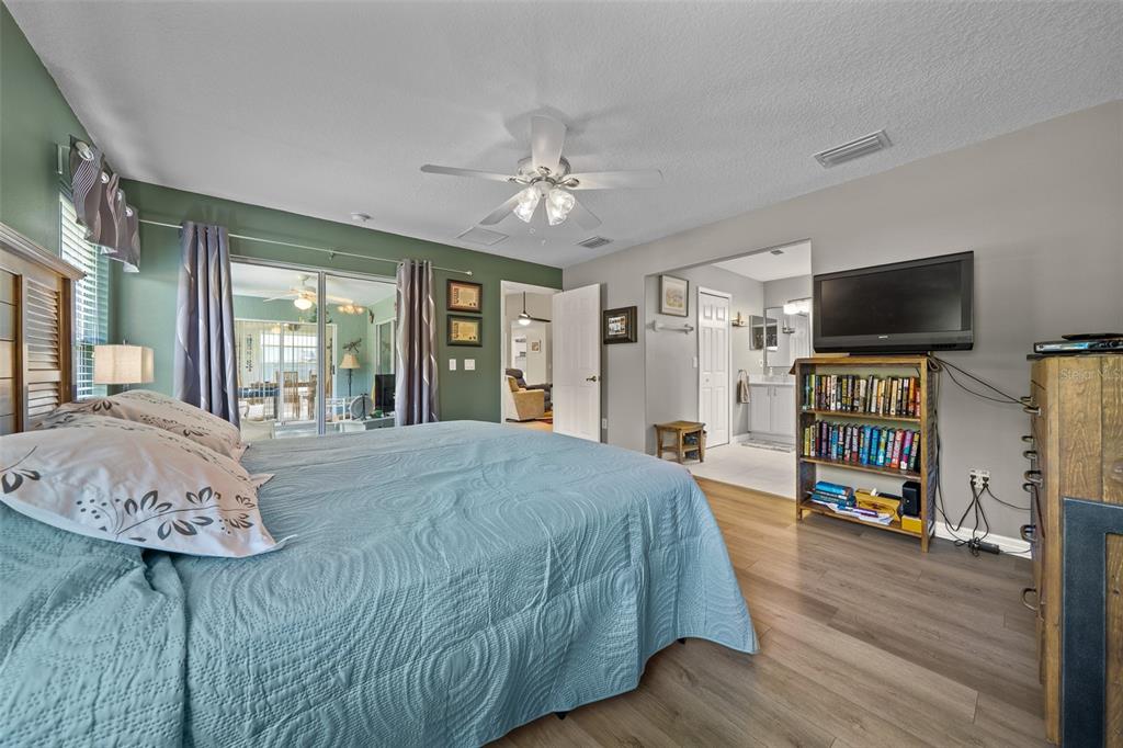 16193 Southwest 14th Avenue Road Ocala, FL 34473 - Photo 35 of 74 a spacious bedroom with a bed and a flat tv screen on the dresser