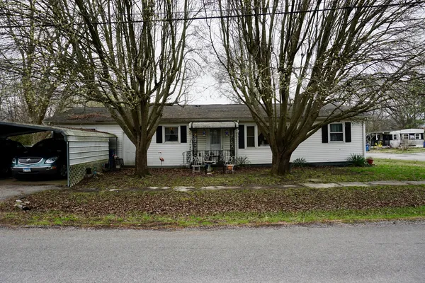 a view of a house with a yard and large tree