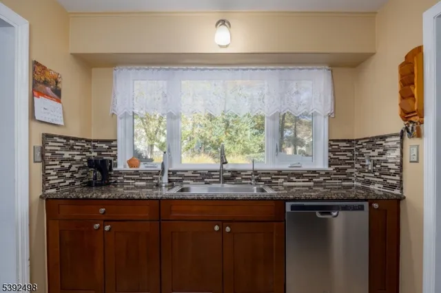 a bathroom with a granite countertop sink and a window