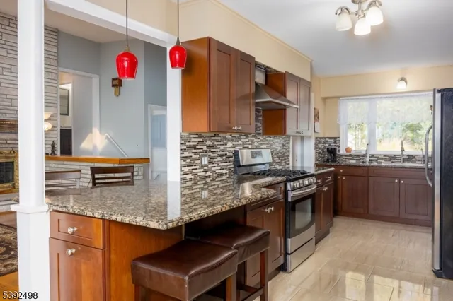a kitchen with stainless steel appliances granite countertop a stove a sink and a refrigerator
