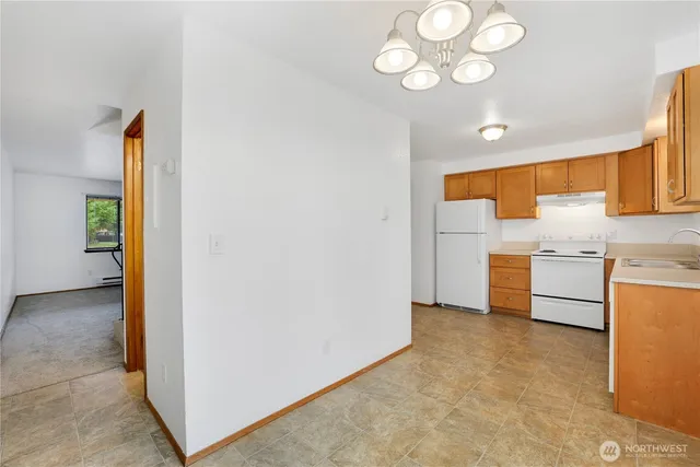 a view of kitchen with granite countertop cabinets and refrigerator