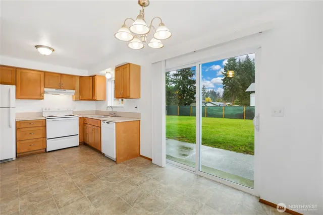 a kitchen with kitchen island a large window cabinets a sink a stove and a refrigerator