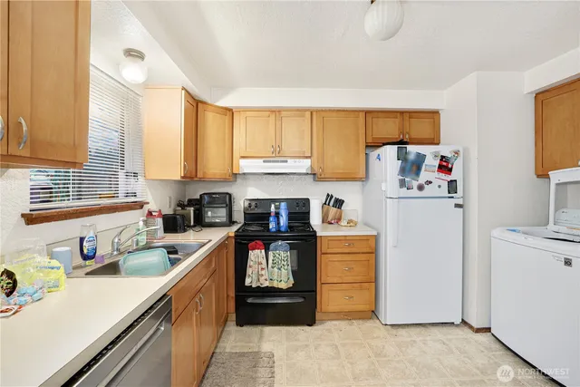 a kitchen with a refrigerator a stove a sink and a window