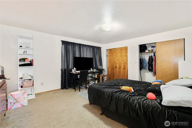 a bedroom with a bed and a flat screen tv